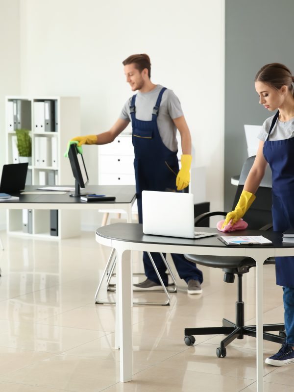 Team of janitors cleaning office